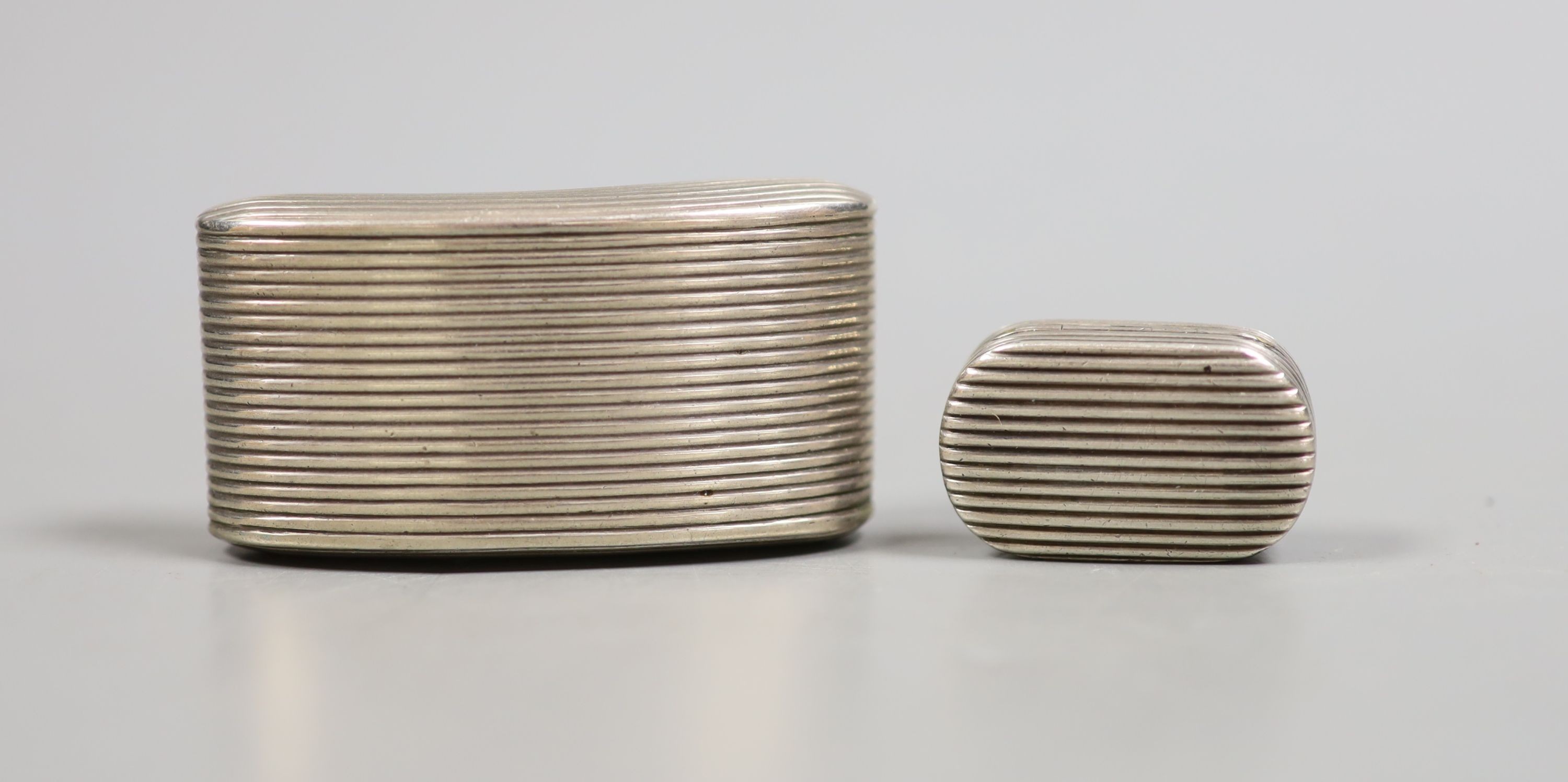 A George III reeded curved silver snuff box, Joseph Wilmore, Birmingham, 1807, 62mm and similar oval vinaigrette, John Shaw, Birmingham, 1807, 33mm.